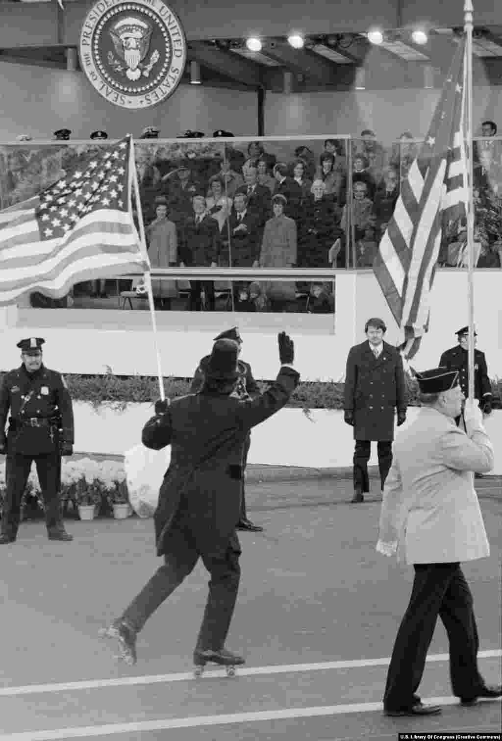 Удзельнік інаўгурацыйнага параду на ролікавых каньках салютуе прэзыдэнту Джымі Картэру на цырымоніі яго ўступленьня на пасаду 20 студзеня 1977 году.