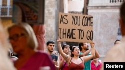 "Ако идвате вие, трябва да си тръгна аз", пише на плакат, издигнат от протестираща в Палма де Майорка.