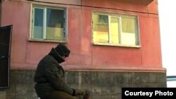 Житель города греется на улице у костра возле дома в Приозерске. Январь 2011 года.   