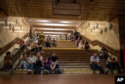 Людзі ў Кіеве хаваюцца ад расейскай атакі ў пераходзе мэтро. 6 чэрвеня 2025 году