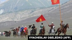 Конники несут флаги Кыргызстана на Всемирных играх кочевников. Семеновское ущелье.