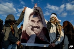 Молоді прихильники Абдулли Оджалана з його портретом на вулиці в місті Д’ярбакір на південному схожі Туреччини. Лютий 2025 року
