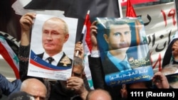 گروهی از هواداران جنگ روسیه علیه اوکراین تصاویر بشار اسد و ولادیمیر پوتین را در دست دارند 