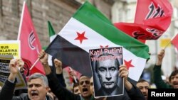 Yslama tarapdar demonstrasiýaçylar Siriýanyň oppozisiýa baýdagyny galdyryp, Orsýete protest bildirýärler. Stambul, 27-nji noýabr, 2015.