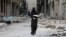 Syria -- A woman carries bread through a damaged street in Aleppo, January 30, 2017