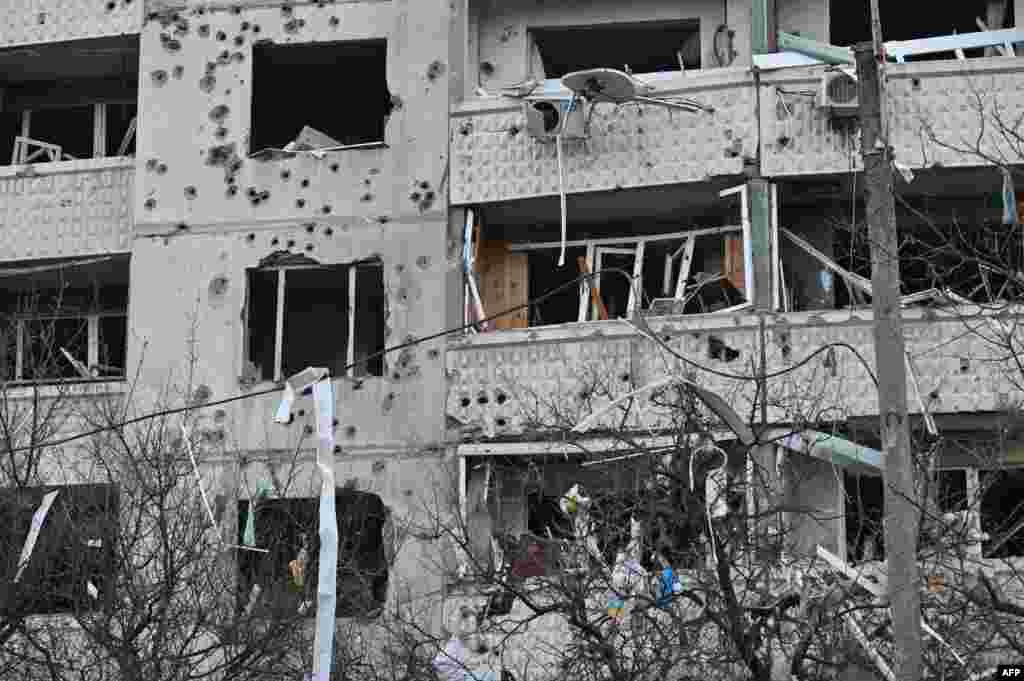 Это фото, сделанное 18 апреля 2025 года, показывает повреждённый жилой дом после ракетного удара в Харькове на фоне российского вторжения в Украину. Photo by SERGEY BOBOK / AFP