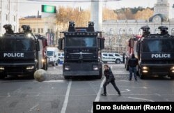 Хлопчик грає на тлі поліцейських вантажівок під час протестів і виборів нового президента, Тбілісі, 14 грудня 2024 року