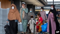 Сім’ї, евакуйовані з Кабула, Афганістан, проходять через термінал після прибуття до Вашингтону у вересні 2021 року