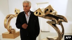 پرویز تناولی در کنار مجسمه‌های «هیچ» که جزو معروف‌ترین آثارش به‌شمار می‌آید