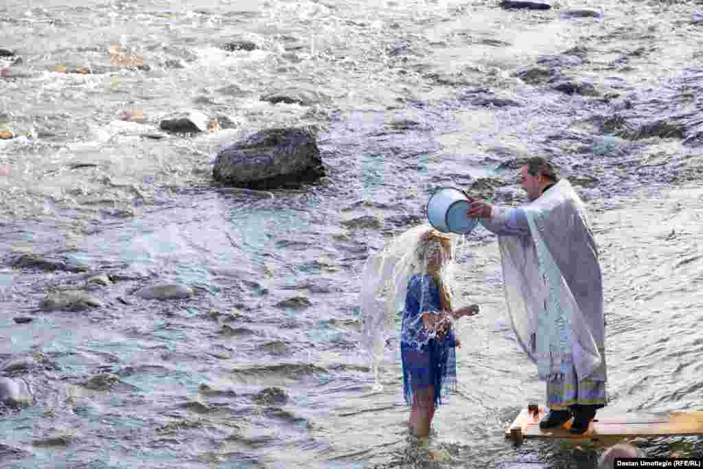 Чиркөө жетекчиси Виктор Реймген алардын башынан ылдый чакалап үч жолудан суу куюп жатты.