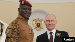 Глава военного правительства Буркина-Фасо Ибрагим Траоре (с Георгиевской лентой) с президентом России Владимиром Путиным перед военным парадом в честь Дня Победы. Москва, 9 мая 2025 года