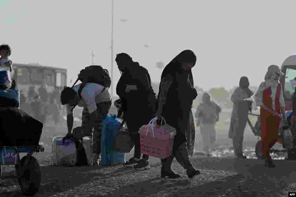 پناهجویان افغان در حال حمل وسایل خود هنگام ورود به نقطه صفر مرزی گذرگاه اسلام‌قلعه پس از اخراج از ایران، ۷ تیر ۱۴۰۴