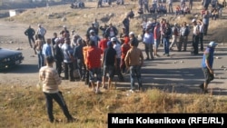 Protesters in Issyk-Kul set fire to a car and block the road on October 8.
