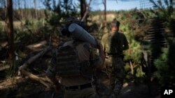 Український військовий несе снаряд до гаубиці на передовій на околицях Лимана, 15 серпня 2023 року