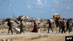 Палестинци се връщат с торби с провизии от пункт за раздаване на храна в централната част на Газа, 5 октомври 2025 г.