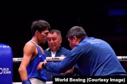 Санжар Тәшкенбай финалда бапкерлерінің кеңесін тыңдап тұр. Ливерпуль, 14 қыркүйек 2025 жыл.