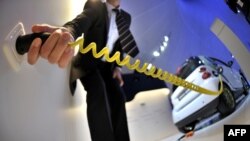 Працівник під'єднує до пристрою живлення електромобіль перед відкриттям 63-го Міжнародного автомобільного ярмароку у Франкфурті. Загалом на виставці представлені 781 авто (серед них близько 100 нових моделей) і автозапчастин від виробників з 30 країн