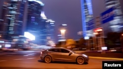 یک خودرو تسلا در حال عبور در خیابانی در شانگهای چین