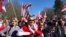 People gathered in a local park for the event, singing patriotic songs and waving flags of the Belarusian People’s Republic.