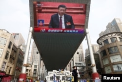 نمایشگری در پکن که حضور شی جین‌پینگ در کنگره خلق جین را نشان می‌دهد، ۱۱ مارس ۲۰۲۱