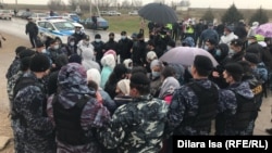 Протестующие попытались перекрыть проезжую часть, но их окружила полиция, а позже увезла в отделение. Люди требовали объяснить им причину задержания директора местного цеха — они беспокоились о рабочих местах. Шымкент, Алтынтобе, 4 апреля 2021 года.    