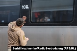 Военный прощается с женой и ребёнком через окно поезда незадолго до его отправления из Краматорска