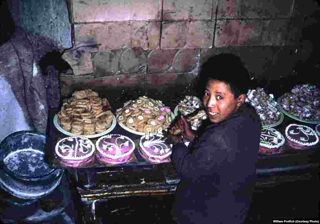 Торт, токоч жана башка ширин даамдарды крем менен кооздоп жаткан бала