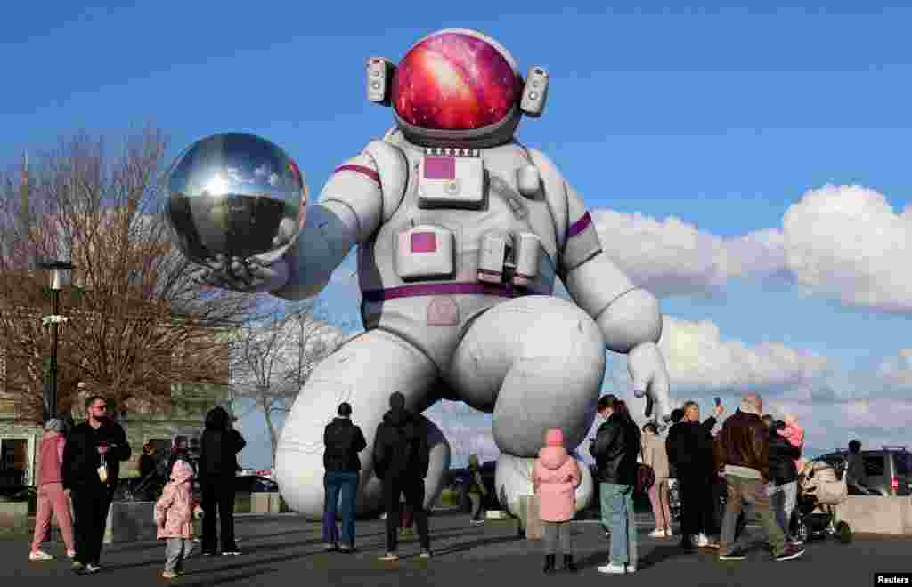 Русия оккупациясендәге Кырым ярымутравының Евпатория шәһәрендә кешеләр мәйданда Космонавтика көне алдыннан урнаштырылган зур һава шарын карарга җыелган.