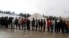 Migrants wait in line to receive food from an aid group at the Vucjak refugee camp near the Bosnia-Croatia border.