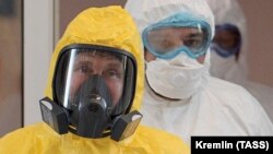 Президент РФ Владимир Путин в желтом защитном костюме во время посещения многопрофильного медицинского центра "Новомосковский", куда госпитализируют пациентов с подозрением на коронавирус COVID-19