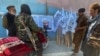 Taliban fighters in Kabul with posters of the militant group's supreme leader, Mullah Haibatullah Akhundzada, who announced dozens of new official appointments on October 4. (file photo) 