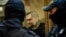Former Russian policeman Vladimir Vorontsov stands inside a defendants' cage during a court hearing in Moscow in July 2020.