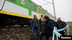 Полският министър-председател Доналд Туск оглежда мястото на повредените железопътни релси по линията Варшава-Люблин на 17 ноември в Мика след експлозия, която той нарече „безпрецедентен акт на саботаж“.