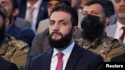 Санкції проти аш-Шараа, раніше відомого як Мухаммад аль-Джулані, запровадили 2014 року через те, що він очолював радикальне ісламістське угруповання «Джебгат ан-Нусра»