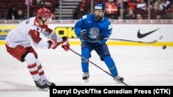 Казахстанский хоккеист Диас Гусейнов (справа) против датчанина Лассе Мортенсена в матче на МЧМ–2019, Ванкувер, 2 января 2019 года.
