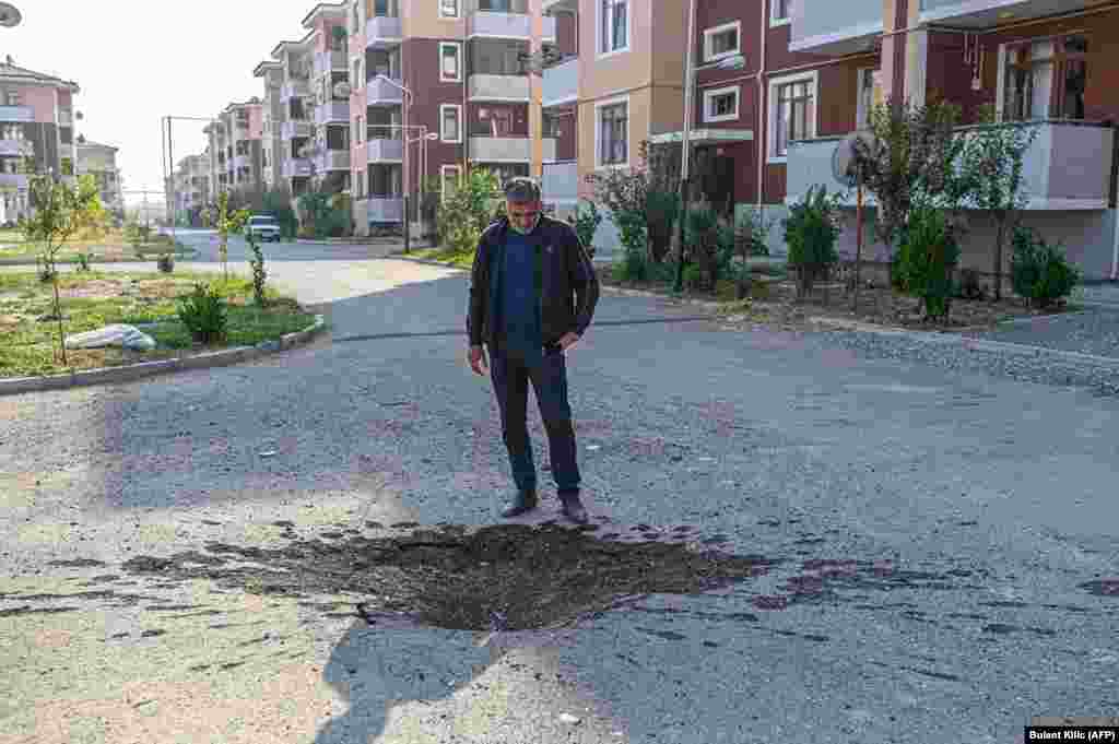Чоловік дивиться на вирву на дорозі в місто Тертер (Азербайджан), недалеко від лінії фронту, 18 жовтня
