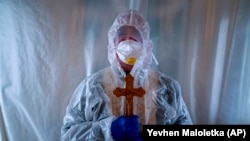 Грекокатолицький священник у захисному костюмі під час візиту до пацієнтів з COVID-19 у відділенні інтенсивної терапії у Львові, 9 січня 2021 року