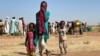 Разселена суданска жена с деца върви в лагер близо до Тавила, Северен Дарфур, на 11 февруари 2025 г., по време на войната между армията и паравоенните сили.