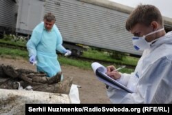 Група експертів офрмлює документи про вилучення зразків ДНК