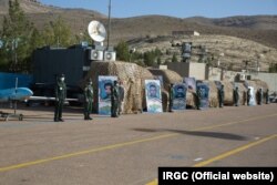 یک پهپاد صادق (مهاجر ۴) در گوشه چپ این عکس و انواع تجهیزات وراداری و جنگ الکترونیک به نمایش درآمده در «میدان صبحگاه» پادگان بعثت نیروی دریایی سپاه در بعد از ظهر ۲۴ اسفند ۱۳۹۹.