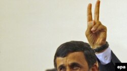 محمود احمدی‌نژاد، رییس جمهور ایران، پس از اعلام توافق ایران با ترکیه و برزیل دست خود را به نشانه پیروزی بالا می برد.