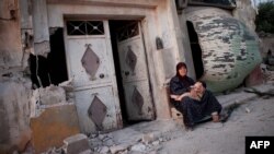 Сирійська жінка біля зруйнованого будинку у селищі в провінції Гама 
