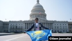 Молодой человек с казахстанским флагом перед зданием Капитолия в Вашингтоне.