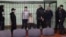 (Left to right) Dzmitry Papou, Artsyom Sakau, Uladzimer Tsyhanovich, Ihar Losik, Syarhey Tsikhanouski, and Mikalay Statkevich in the defendants' cage during the court hearing in Homel on December 14.