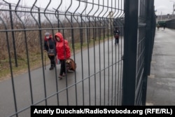 «Коридори» з високої металевої сітки. По одному люди рухаються на вихід, по іншому – на вхід