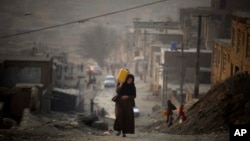 Женщина несет воду в пластиковой емкости, поднимаясь по склону по пути к своему дому в Кабуле, Афганистан. На этой фотографии из архива от 27 декабря 2010 года (AP Photo/Altaf Qadri, архив)