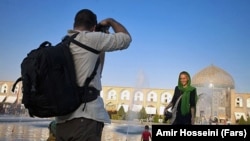 دو گردشگر جوان خارجی در میدان نقش جهان اصفهان، عکس یادگاری می‌گیرند.