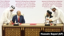 U.S. envoy Zalmay Khalilzad (left) and chief Taliban negotiator Mullah Abdul Ghani Baradar (right) at Doha talks in February