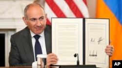 Nikol Paşinyan Azərbaycan prezidenti İlham Əliyev və prezident Donald Trampla imzalanmış üçtərəfli sazişi göstərir.