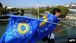 Школьник с флагом грузинской оппозиции. Тбилиси, 2 октября 2012 года.  